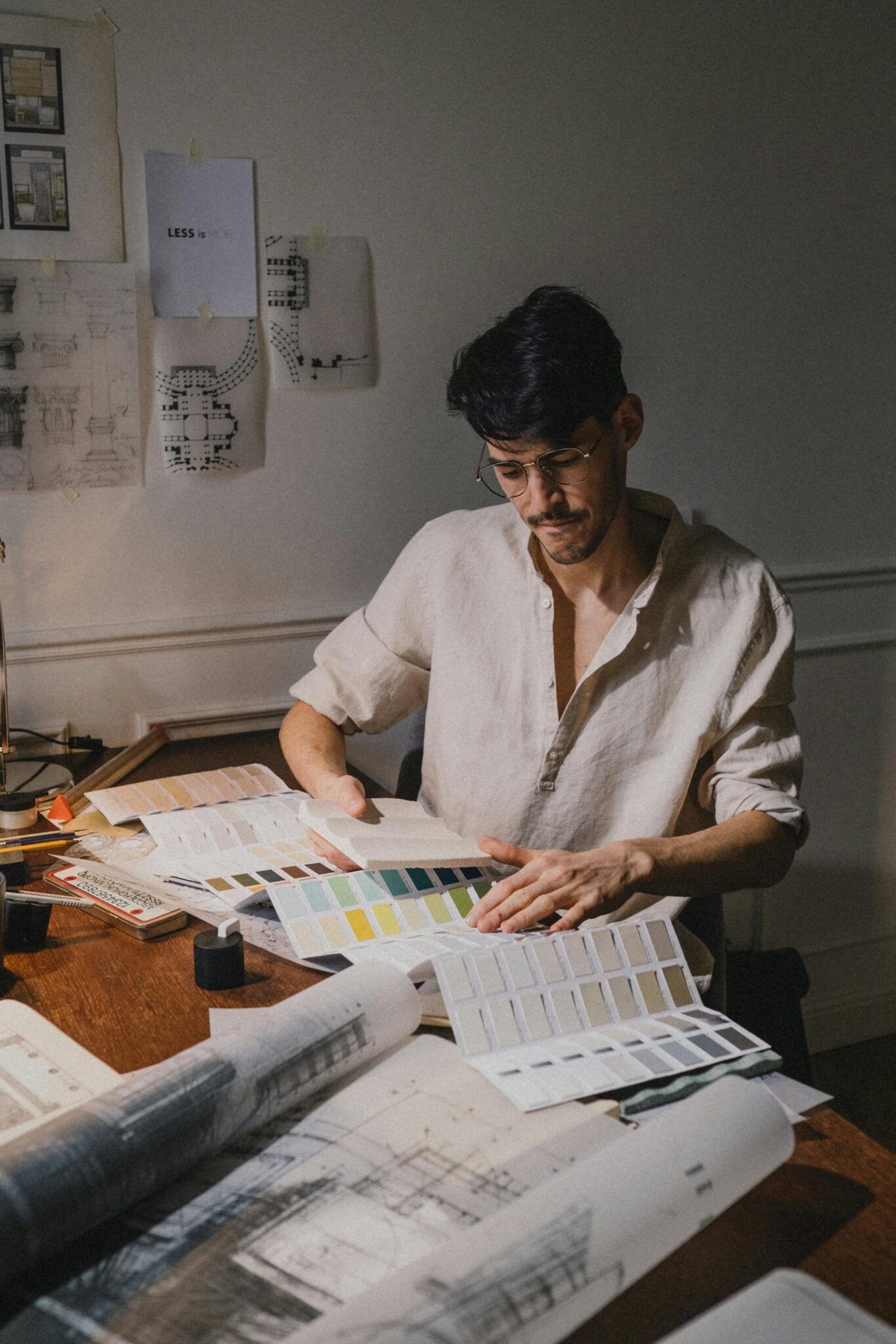 Mano dibujando detalles técnicos sobre plano arquitectónico.